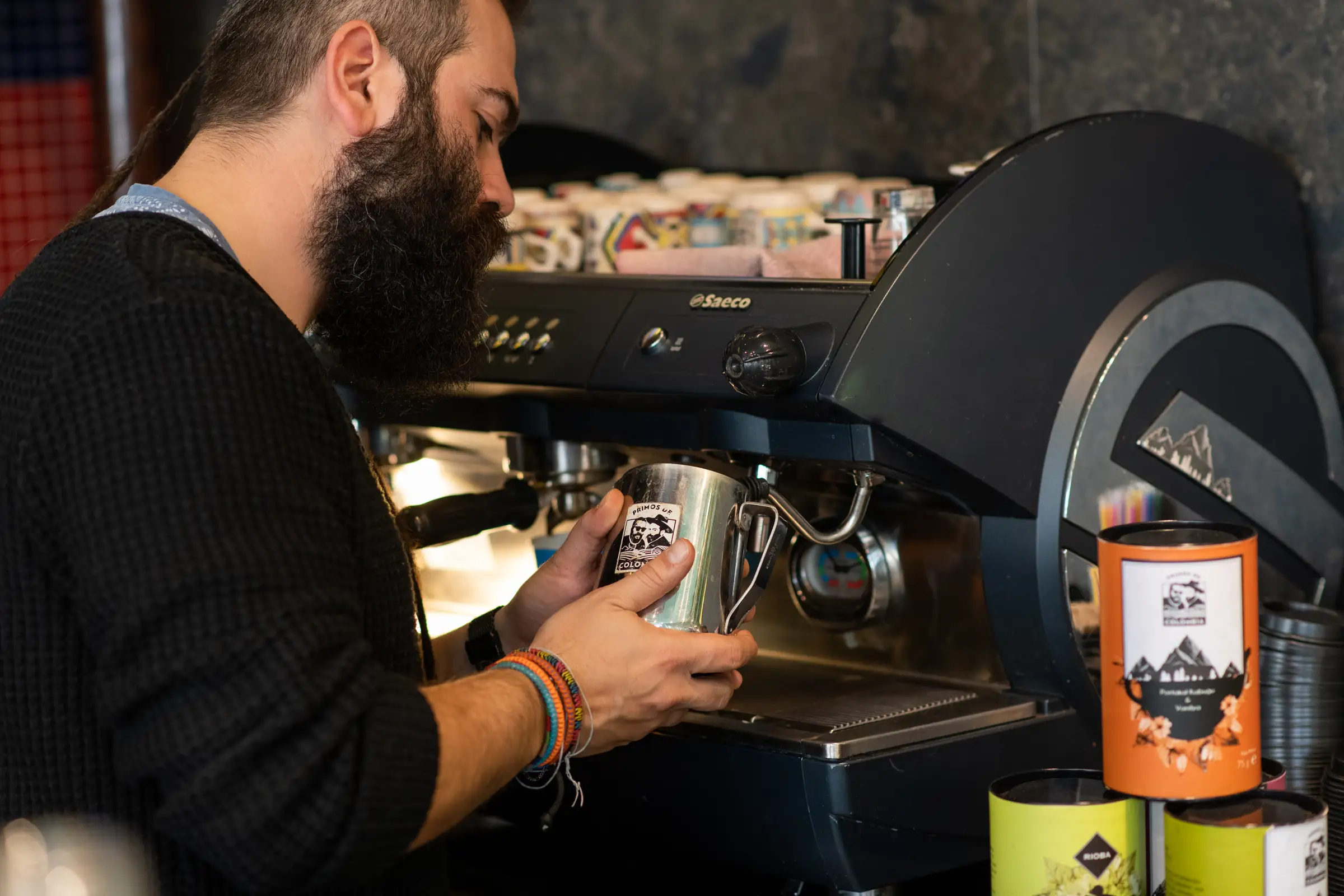 Barista steaming milk at the espresso machine during service