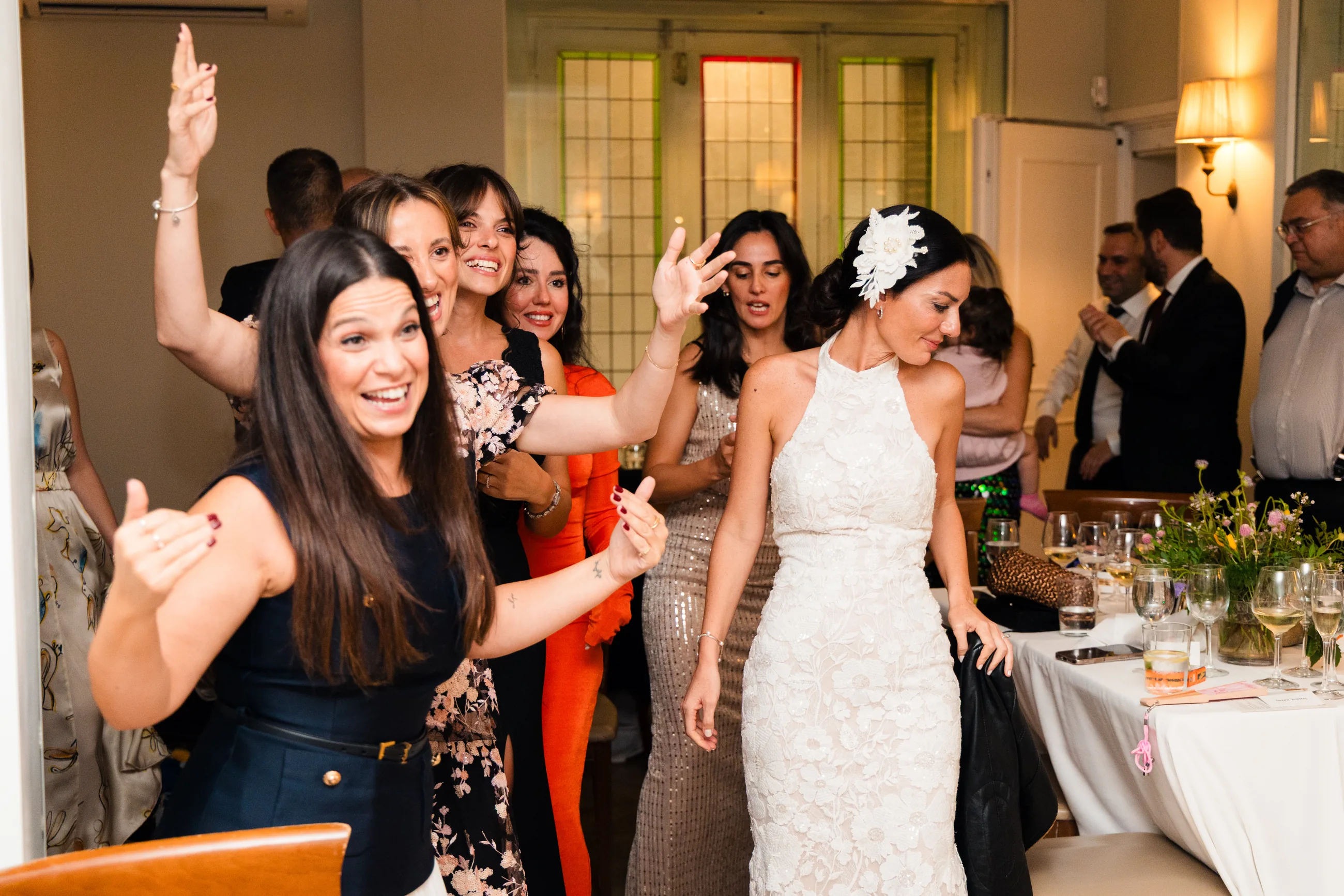 Bride dancing with her friends, arms in the air