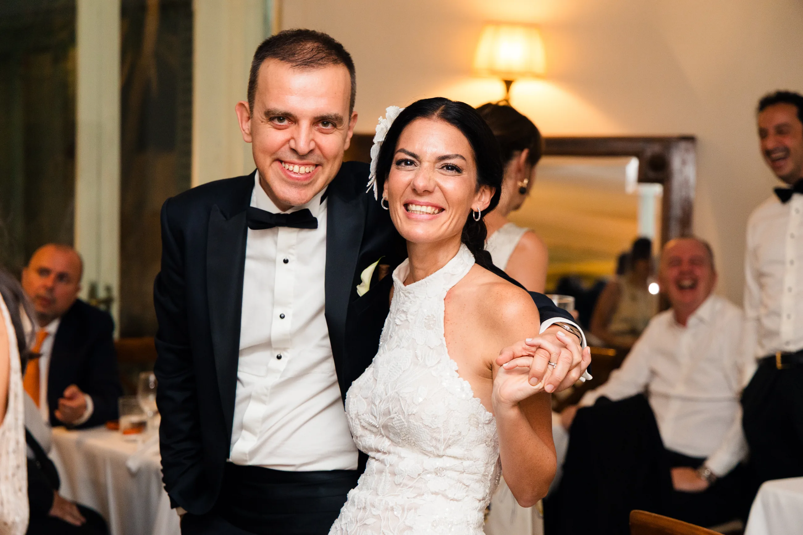 Bride and groom dancing and laughing among their guests