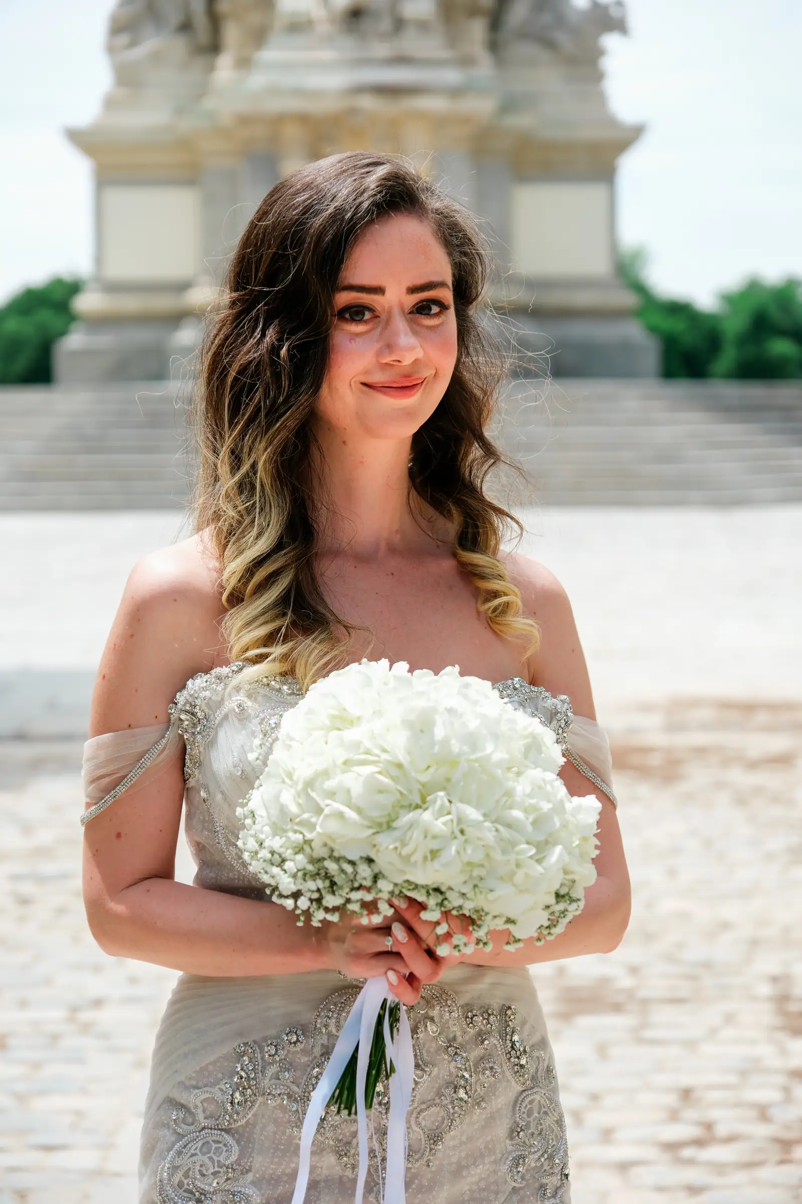 Portrait of a bride with her bouquet in front of a Madrid monument
