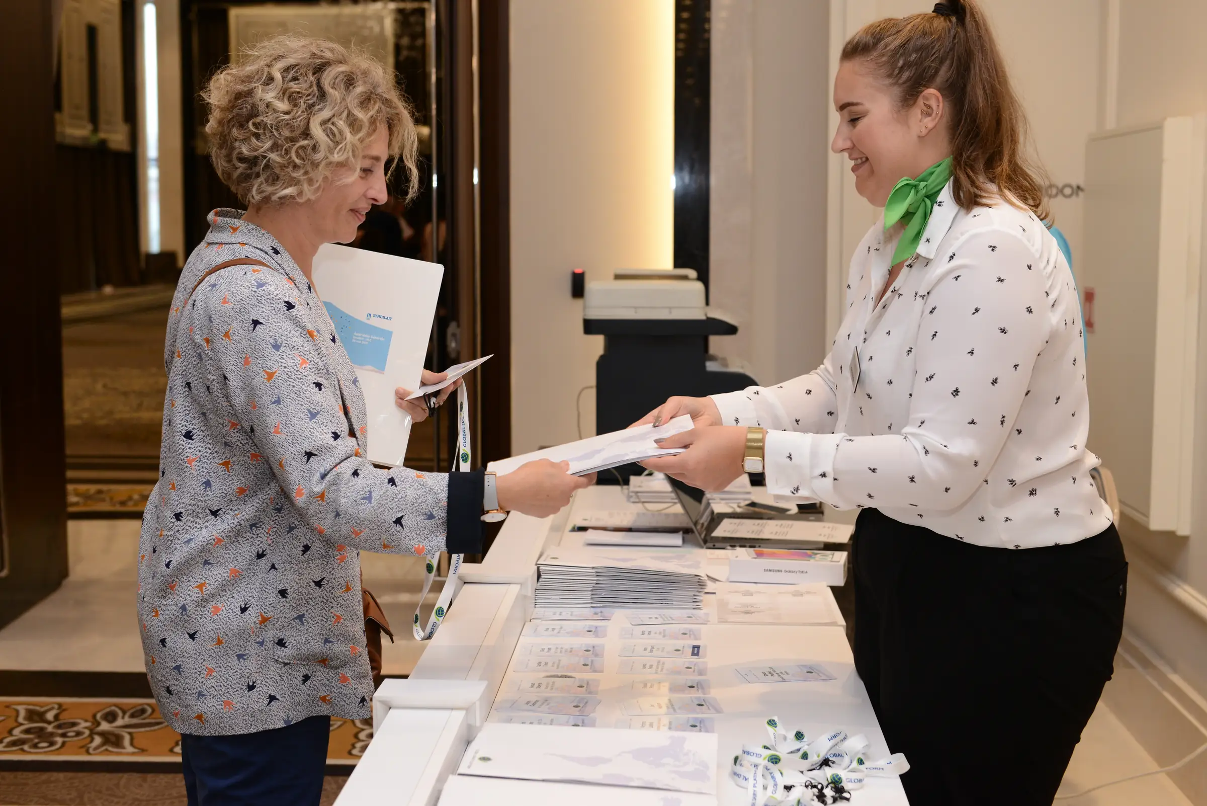 Delegate collecting a badge from a host at the conference registration desk