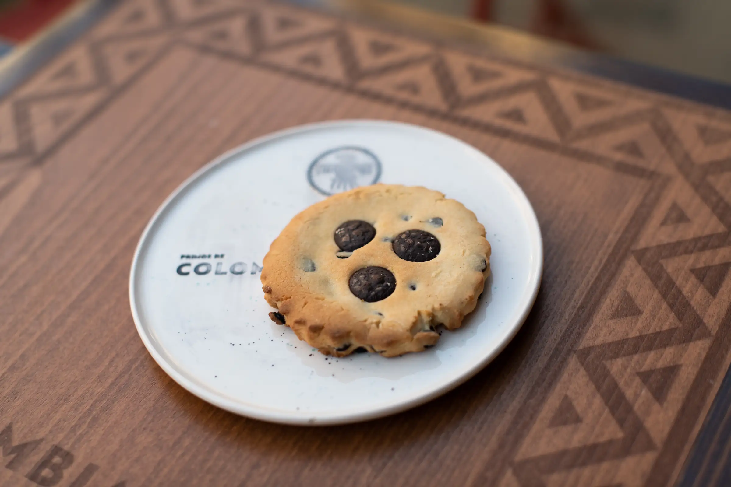 Chocolate chip cookie on a branded ceramic plate