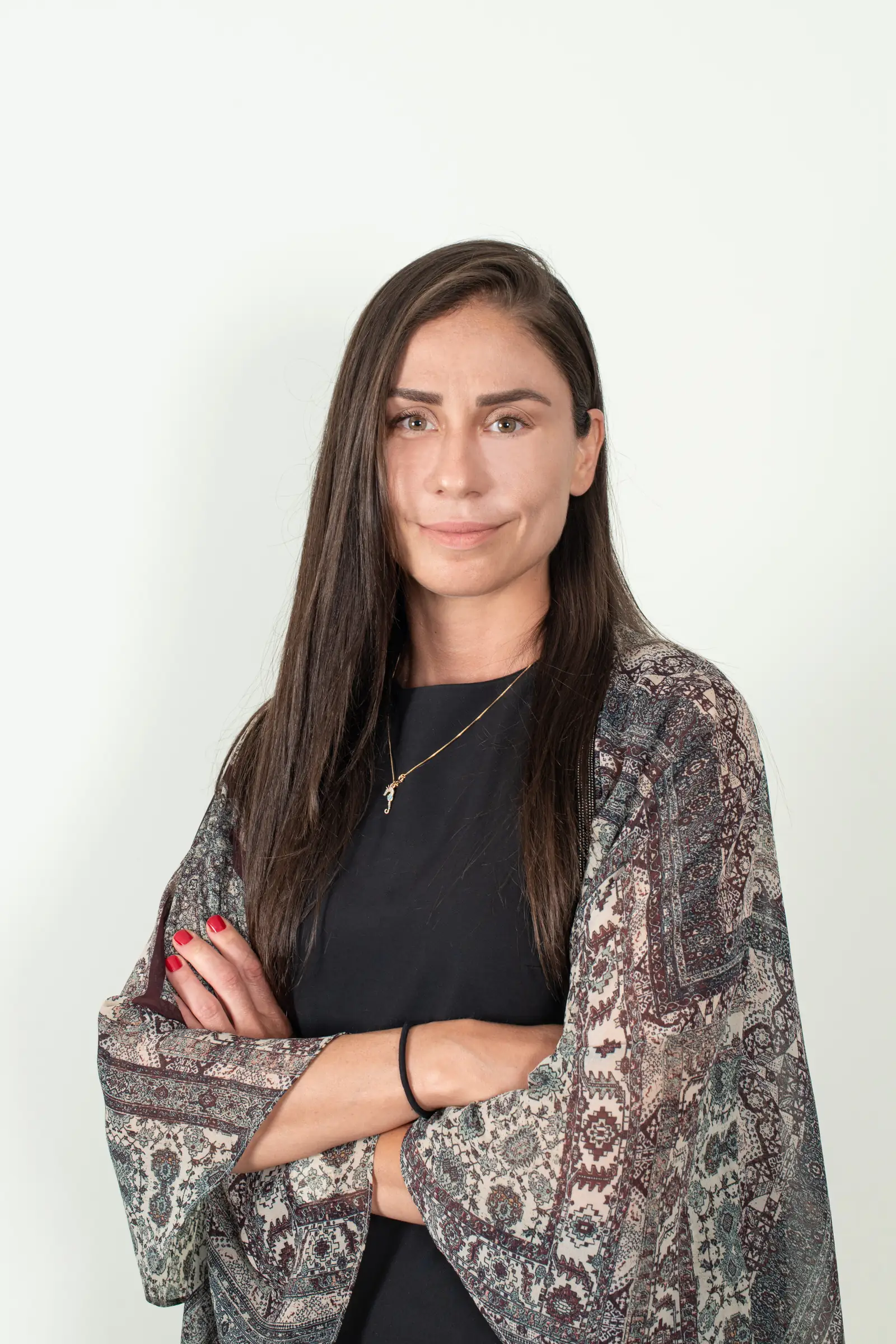 Business portrait of a woman with arms crossed wearing a patterned wrap