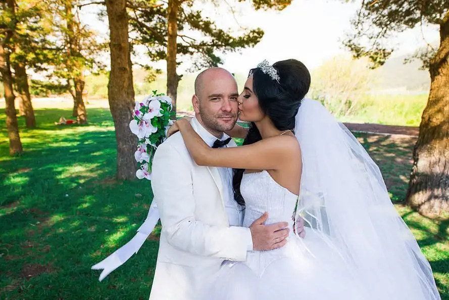 Bride and groom holding each other in a park in autumn