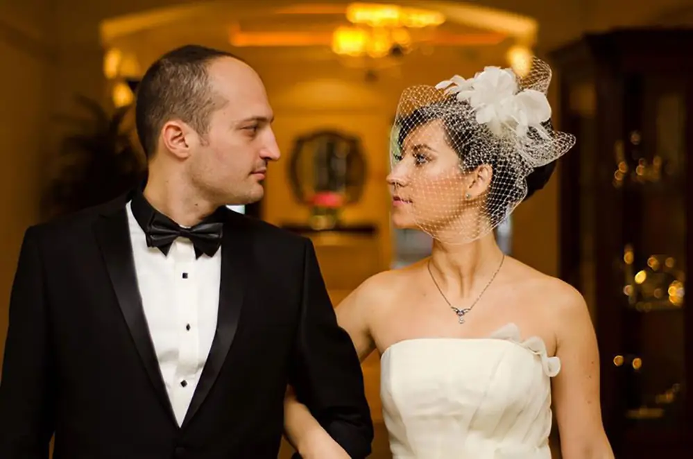 Bride and groom looking at each other in a warmly lit hotel lobby
