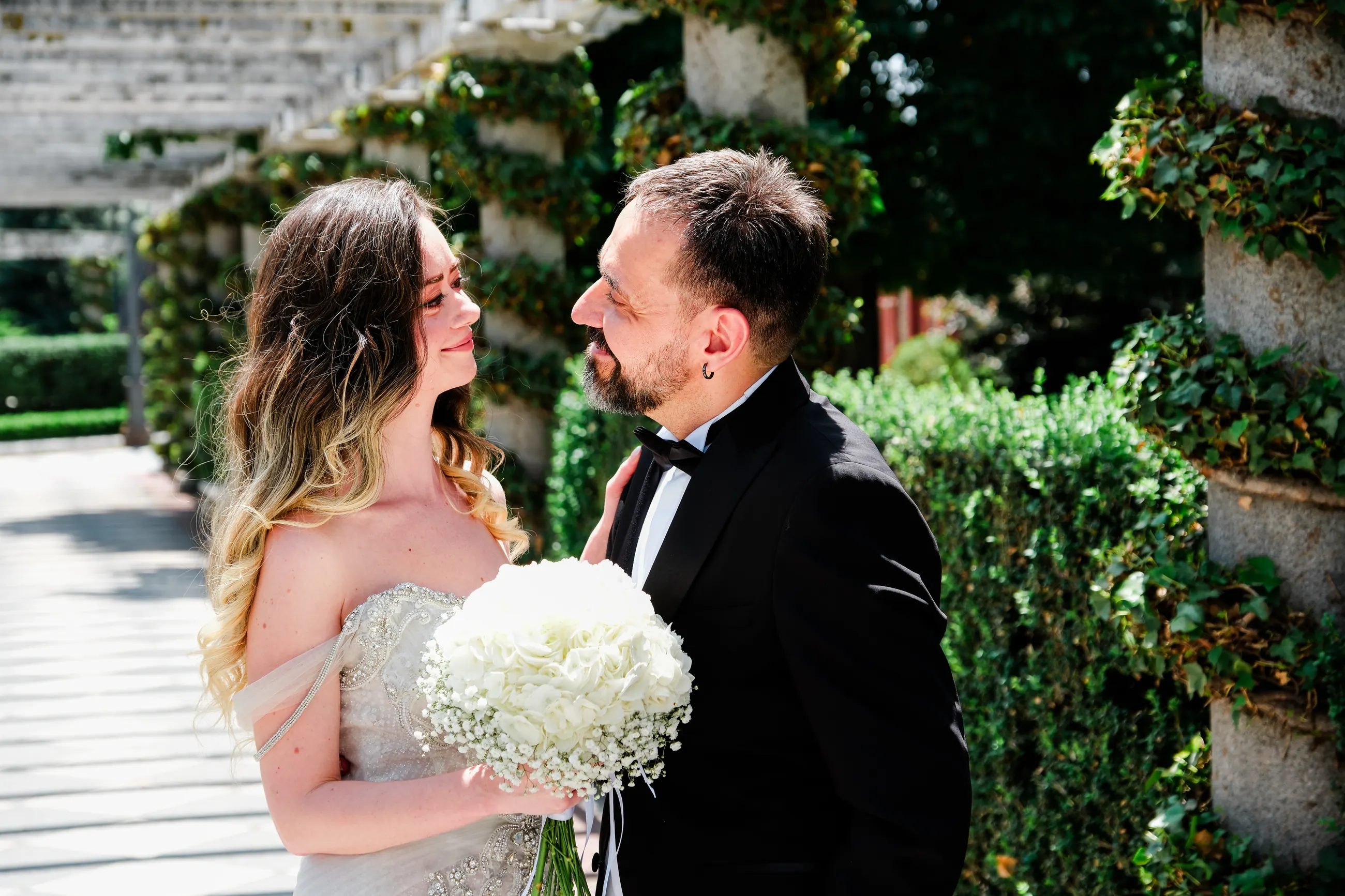 Couple laughing face to face under a stone pergola in Madrid