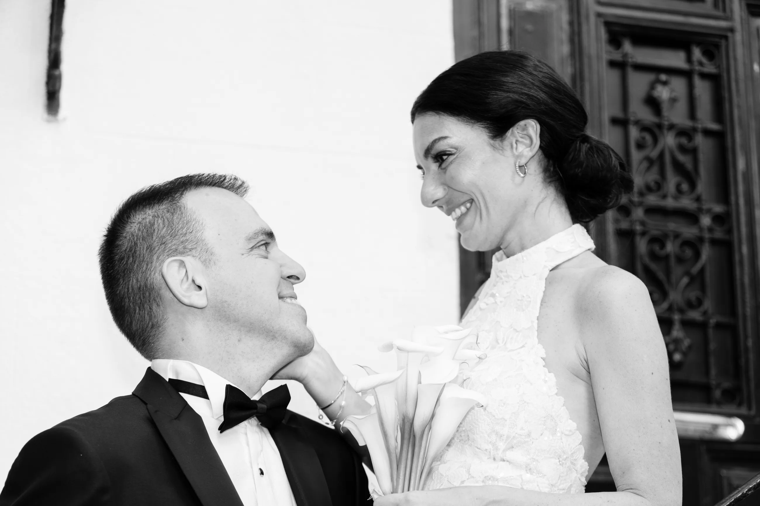 Black and white: the bride and the groom looking at each other in the courtyard