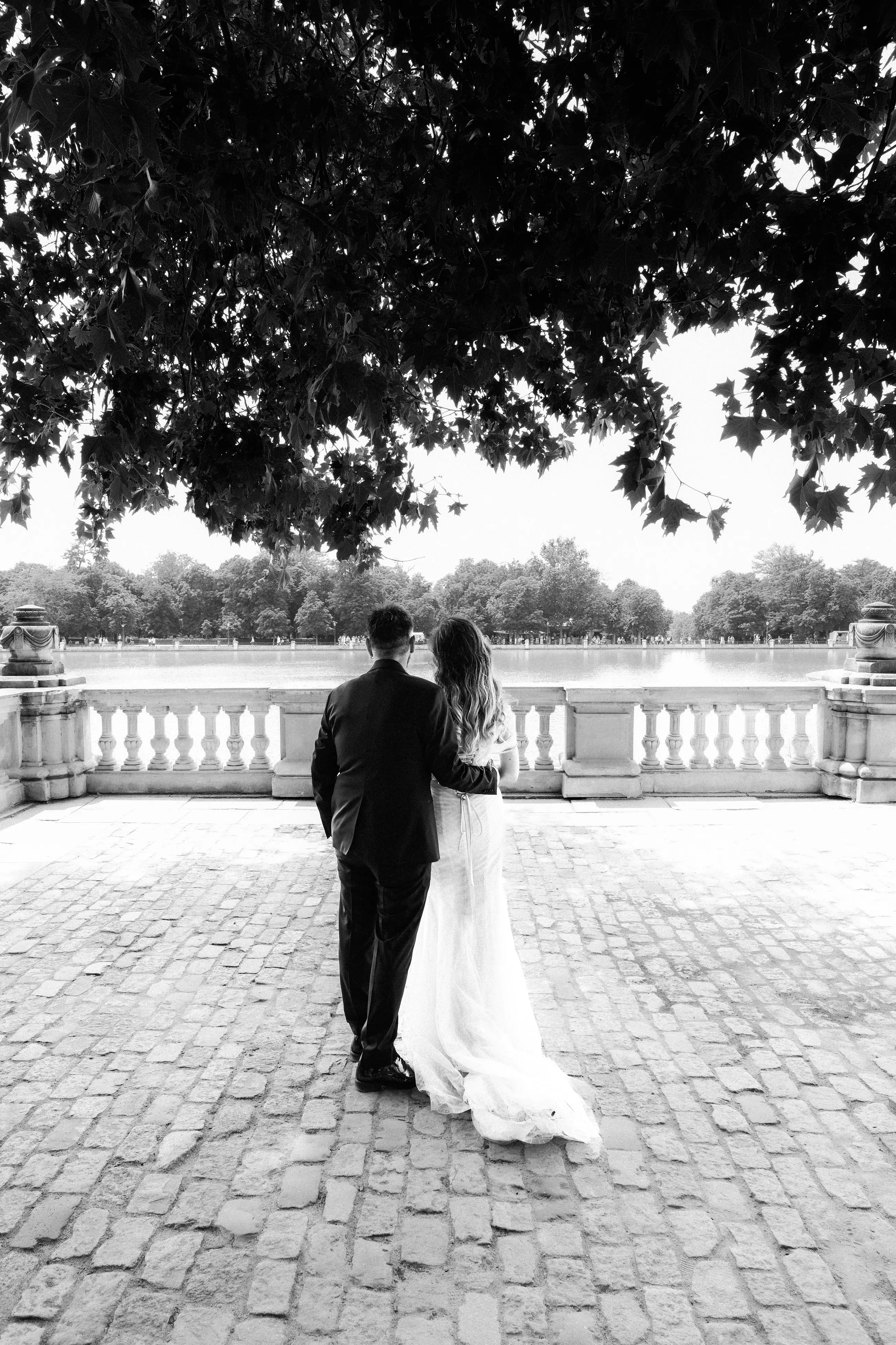 Bride and groom on the balustrade above the Retiro lake in Madrid, black and white