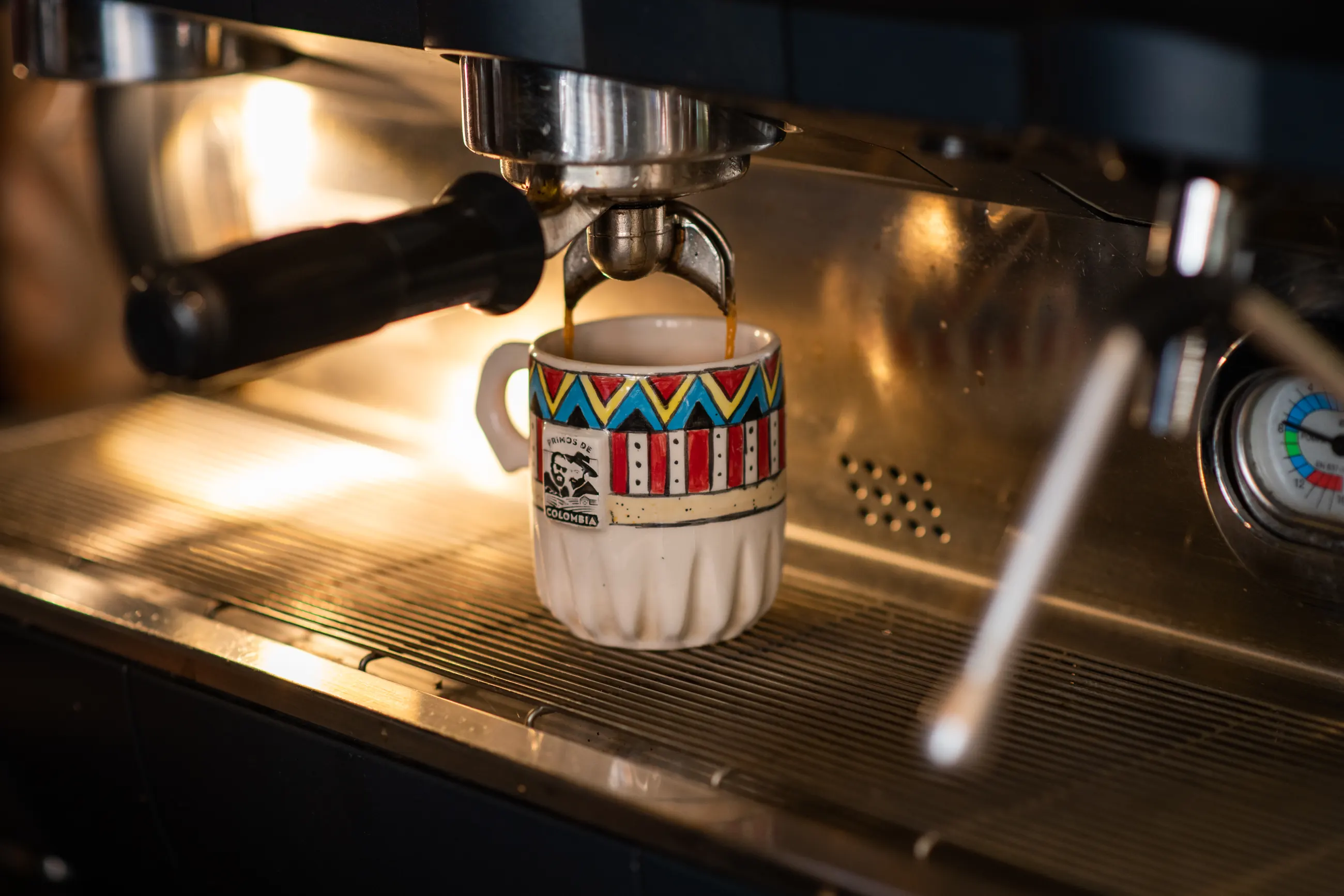Espresso extracting into a patterned ceramic cup under the group head
