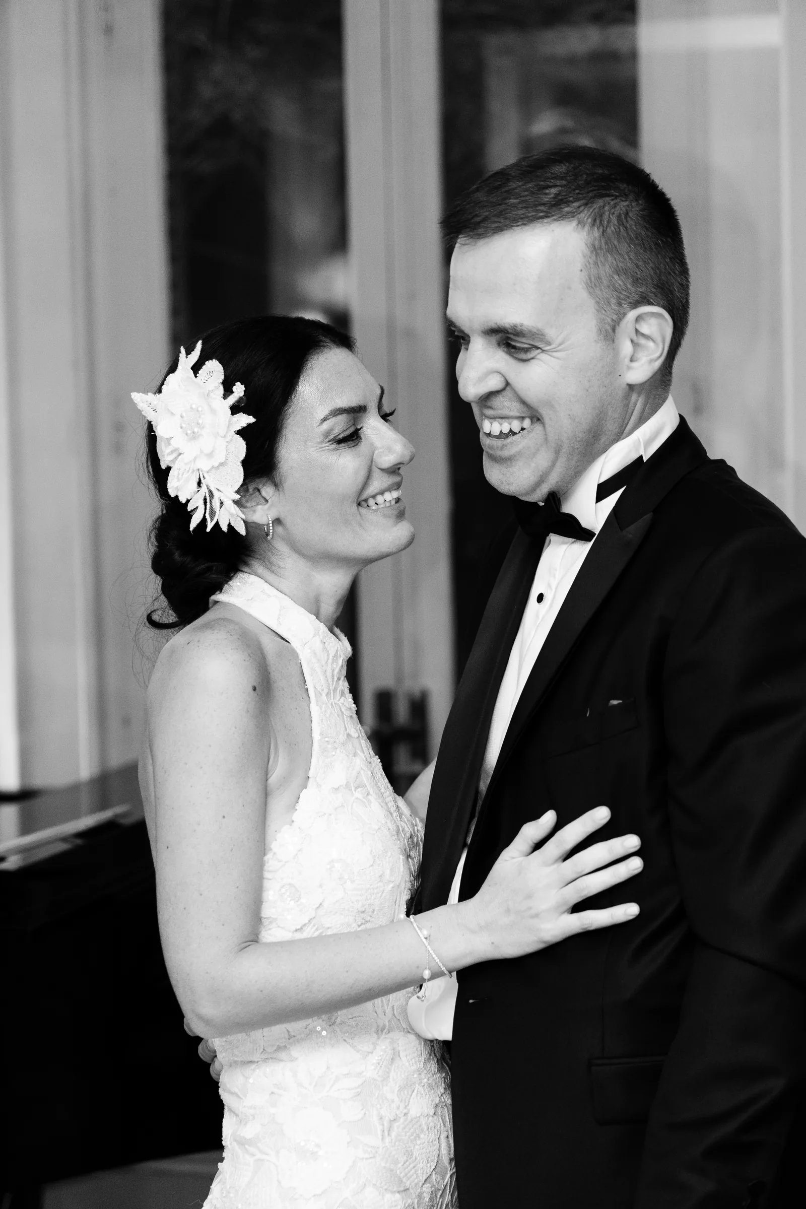 Bride and groom laughing during their first dance, black and white