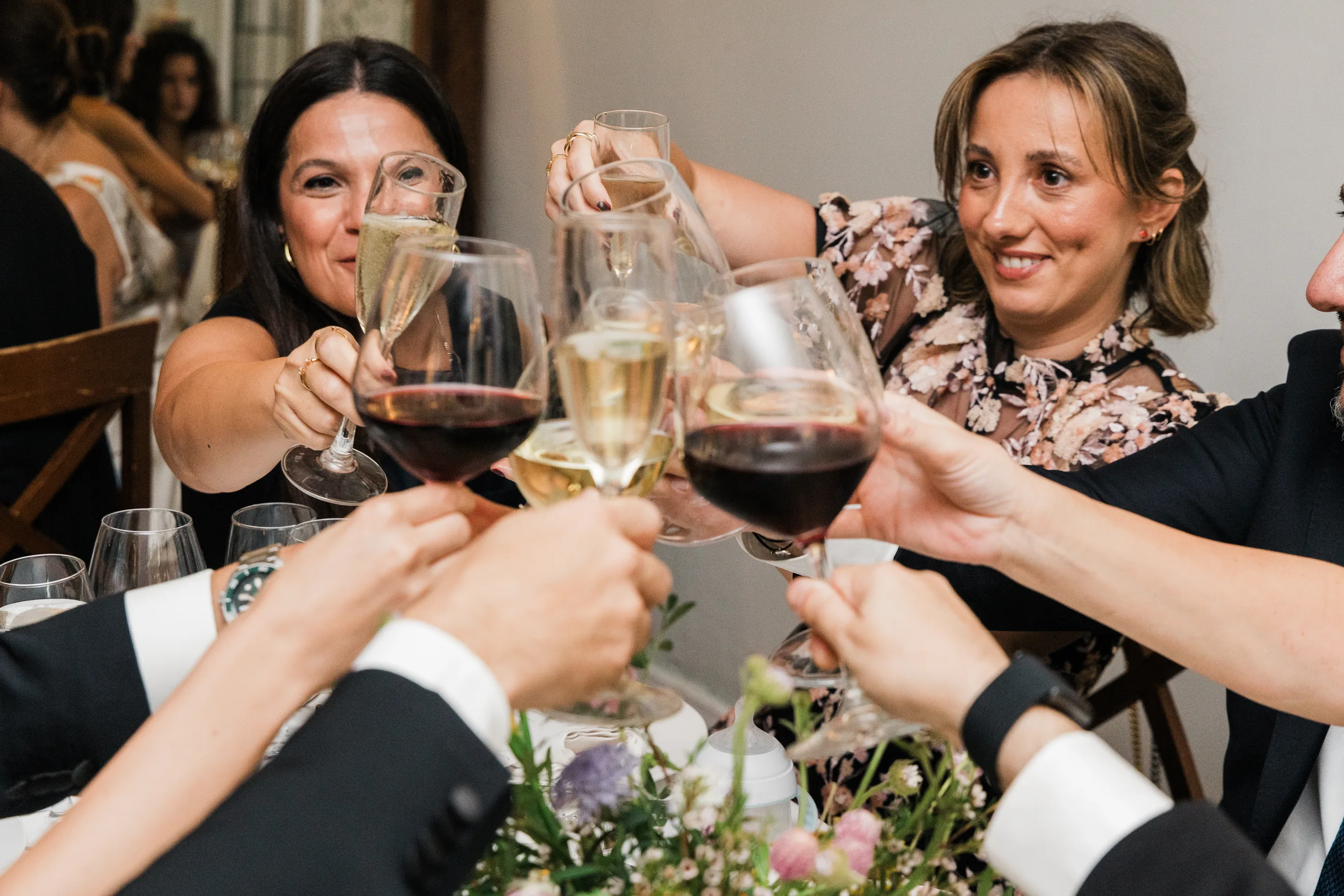 Guests clinking glasses across a dinner table