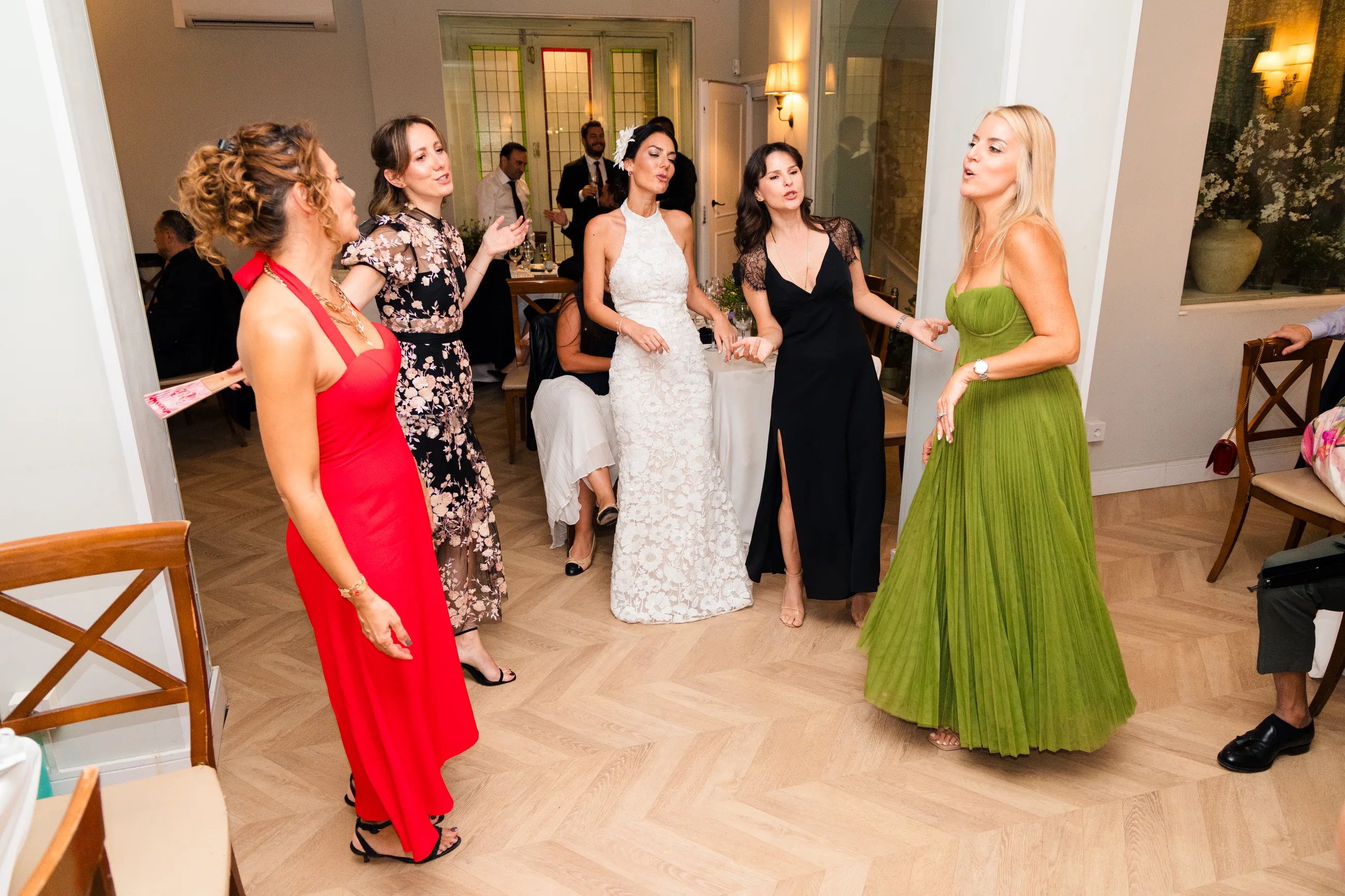 Guests dancing in a lit dining room during an evening party