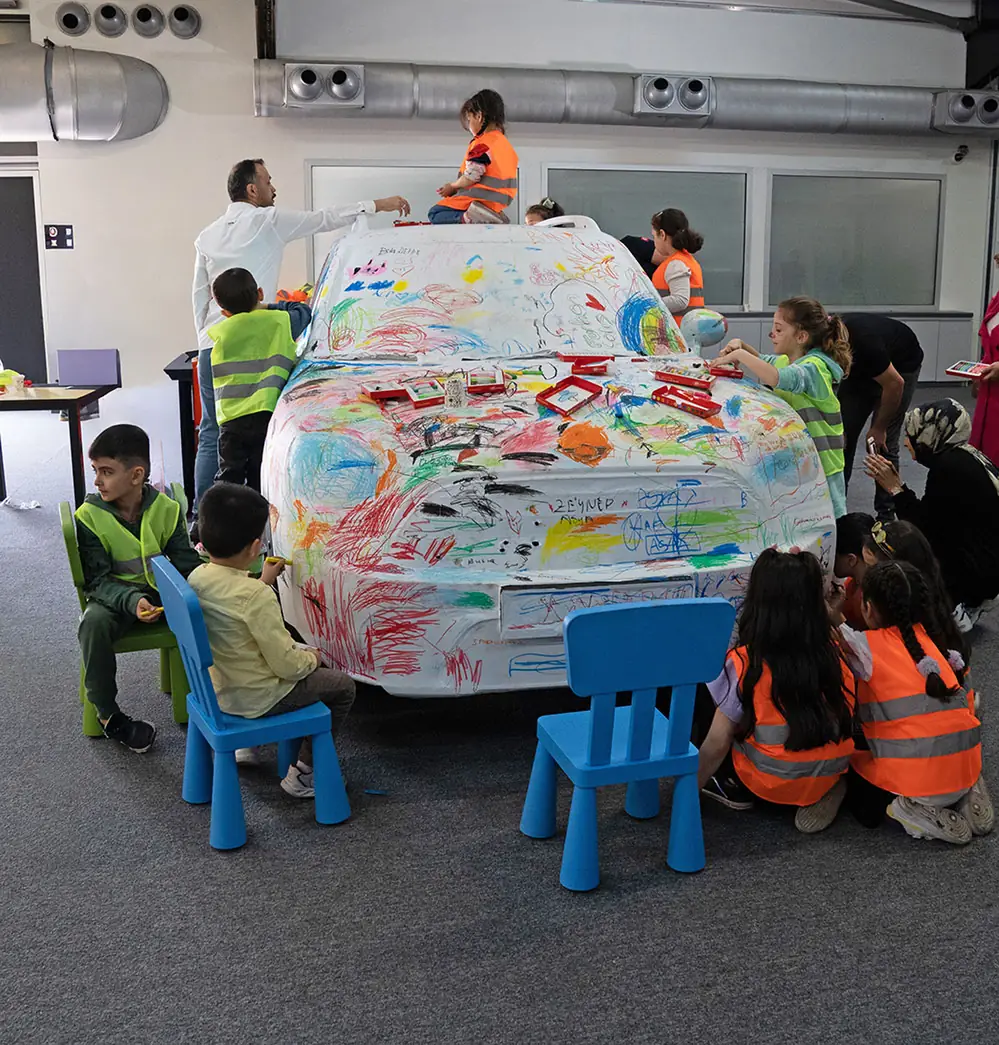 Children painting a car during a workshop