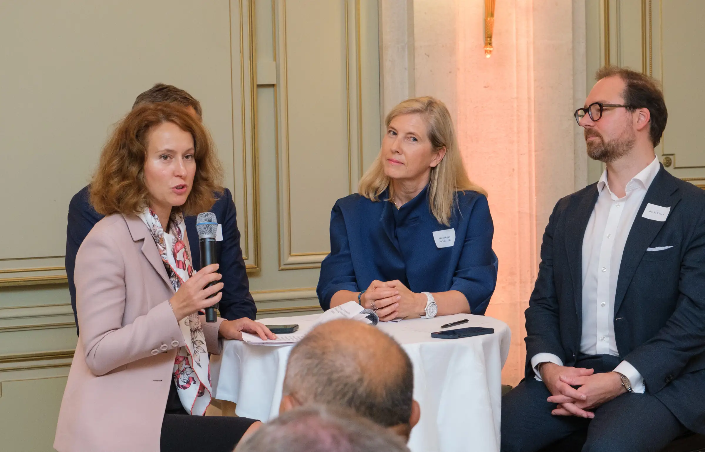 Three panellists seated on stage during a business discussion