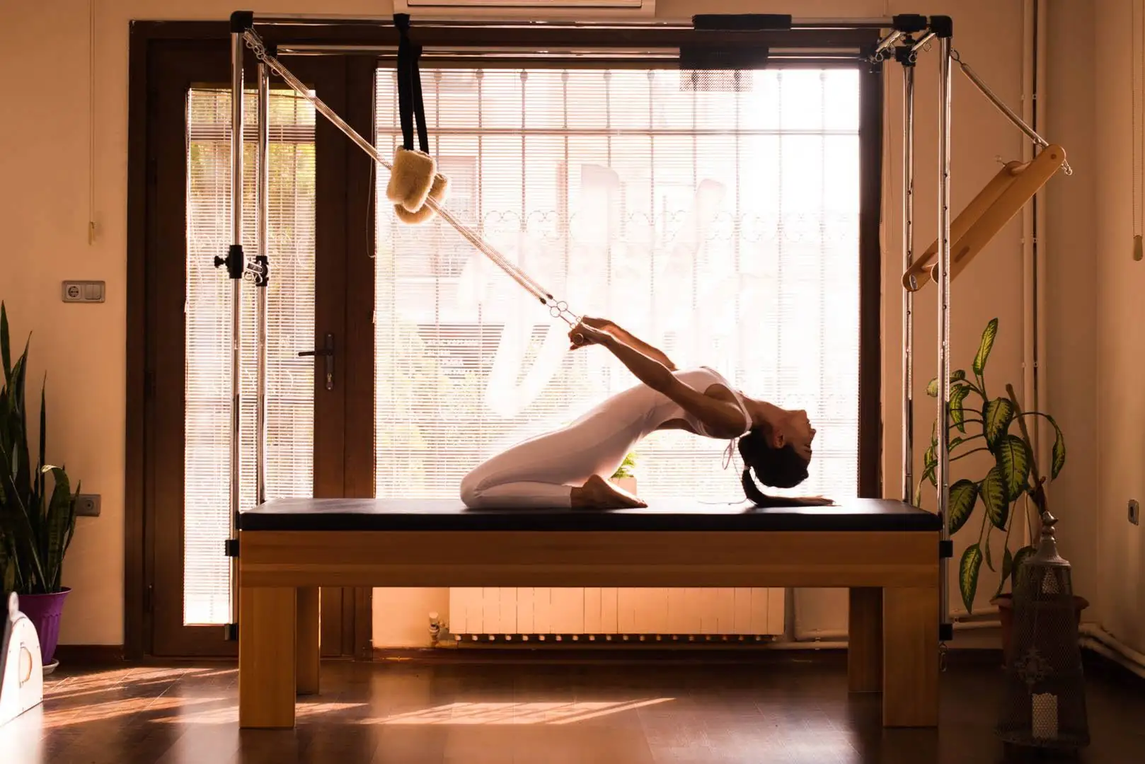 Instructor holding a long extension on the cadillac in a daylit studio