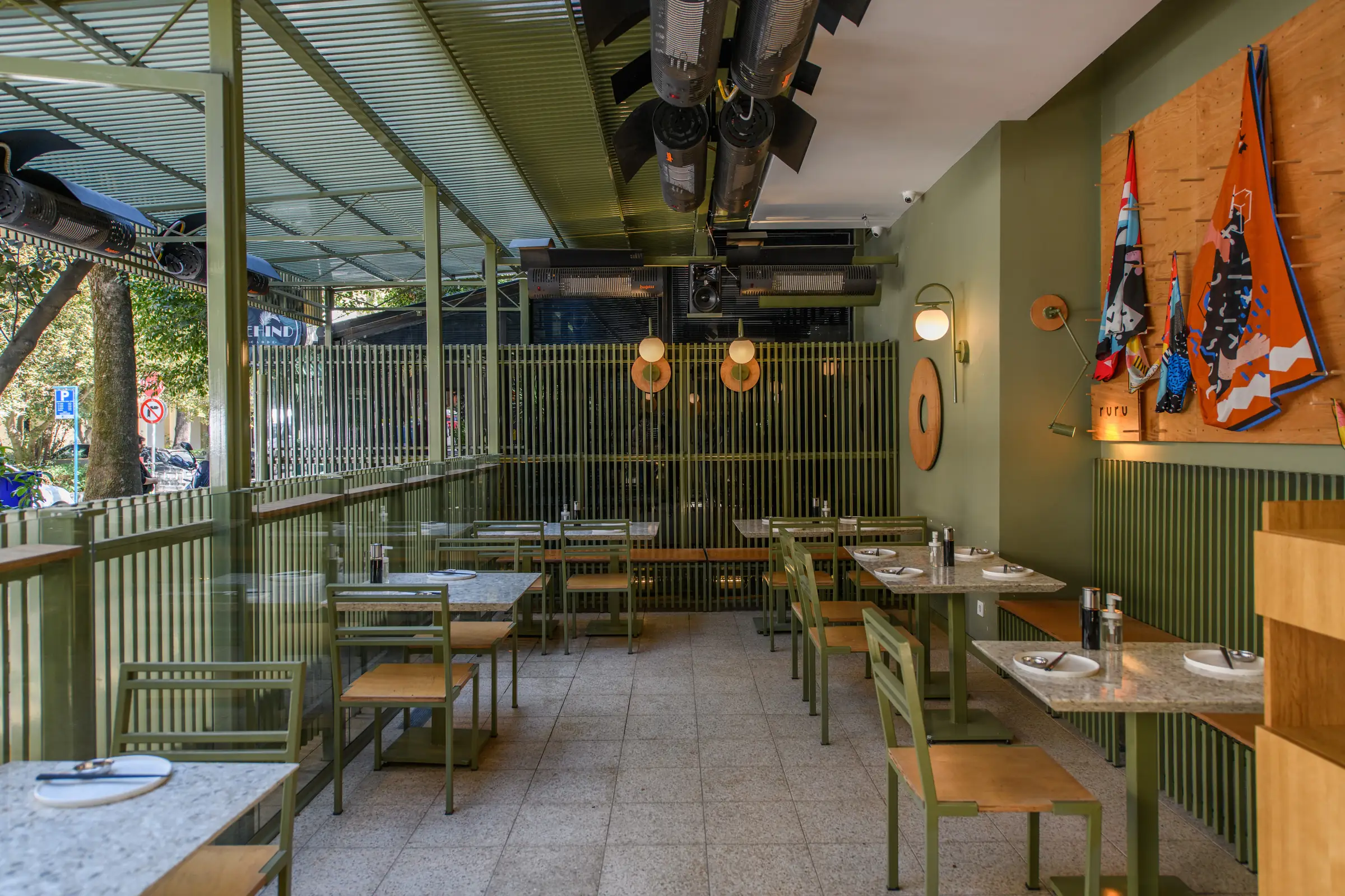 Wide view of a restaurant dining room with laid tables and daylight