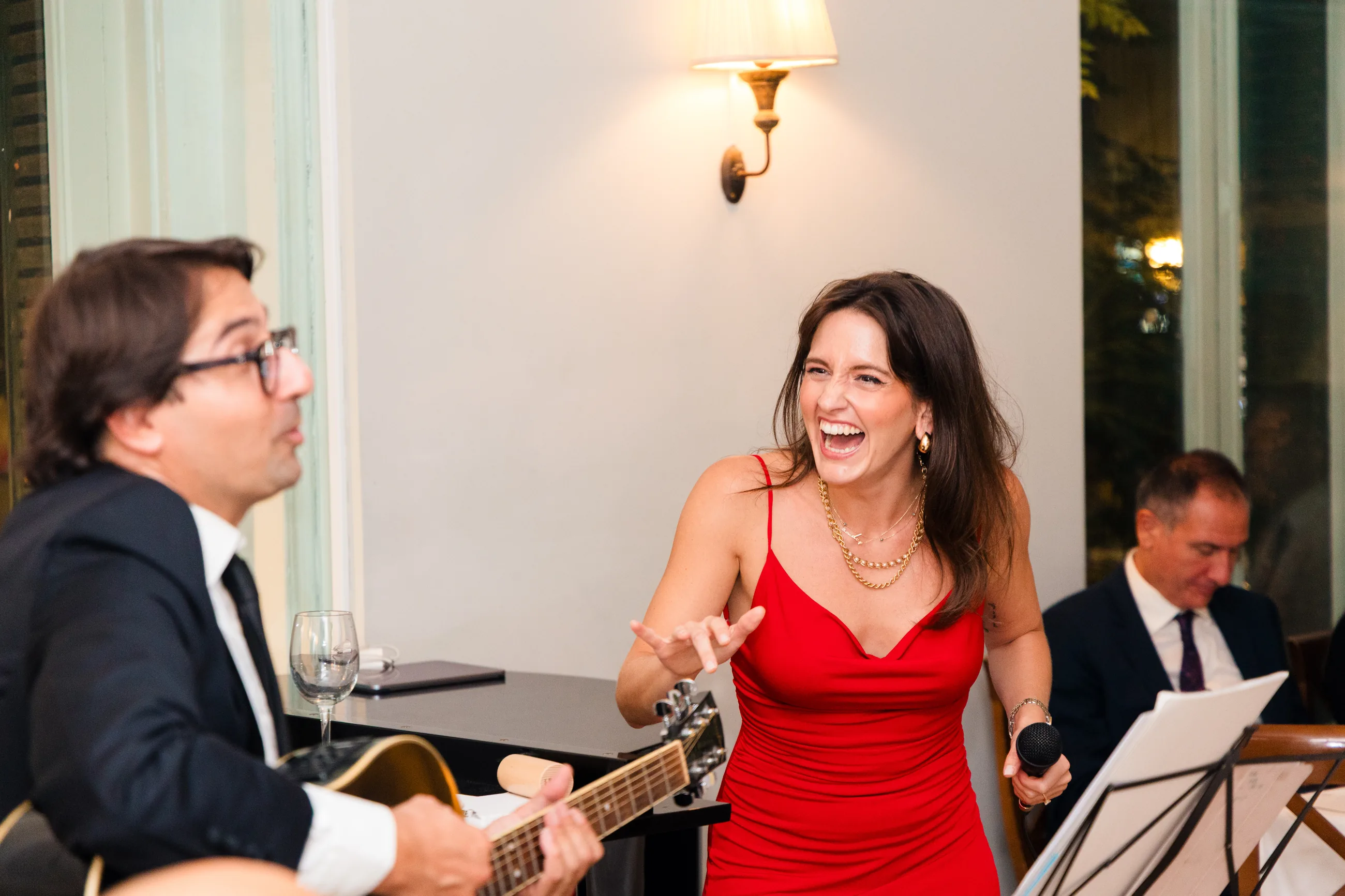 Singer laughing with the guitarist during live music at a private party