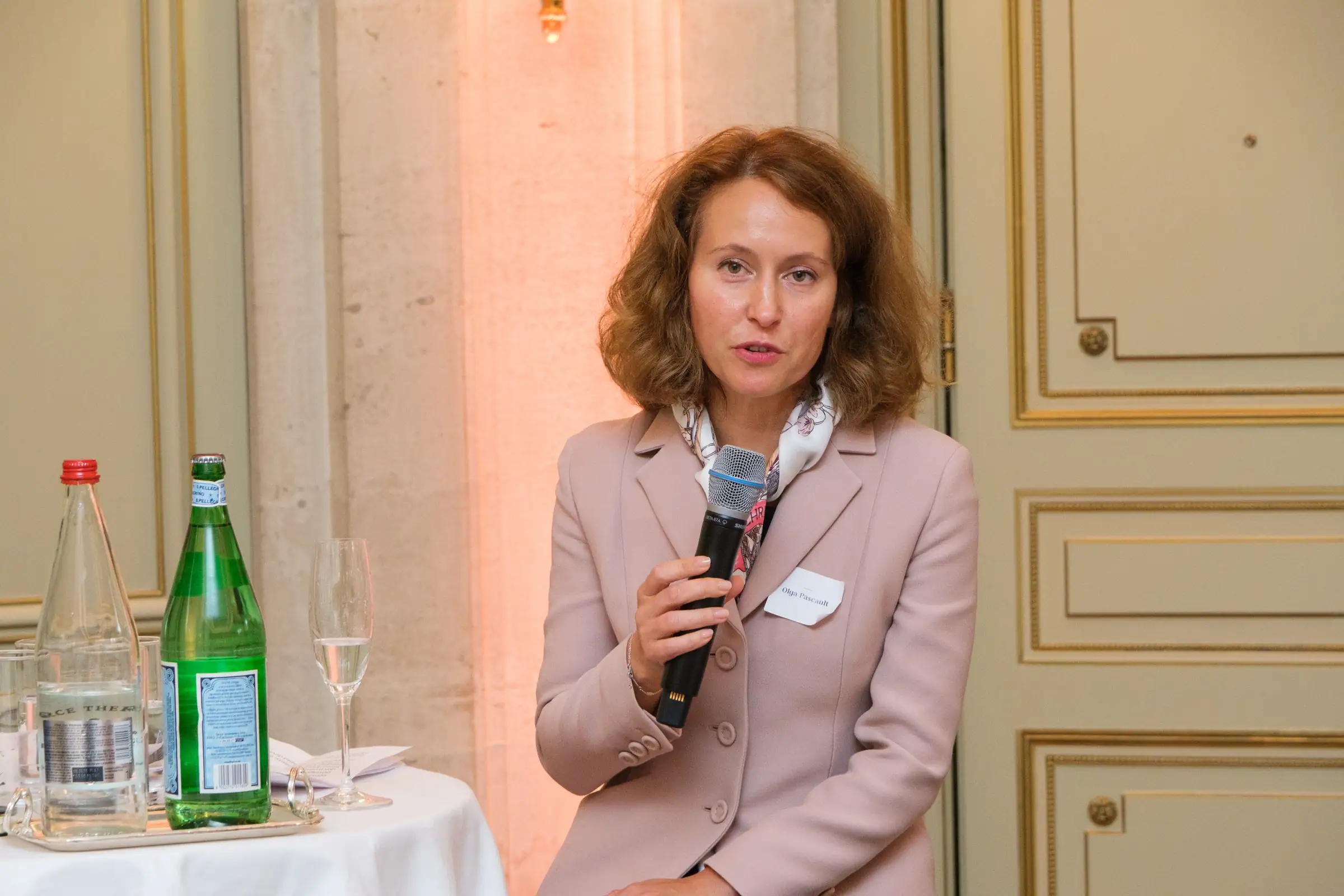 Speaker holding a microphone while addressing guests in a hotel salon